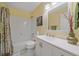 Bright bathroom with a white vanity, tiled walls, and a shower-tub, offering a clean and functional space at 10389 W Fair Ave # E, Littleton, CO 80127