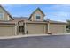 Exterior view of townhome with attached garages, tidy landscaping, and inviting curb appeal at 10389 W Fair Ave # E, Littleton, CO 80127