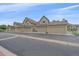 Exterior shot of townhomes featuring attached garages and well-manicured landscaping at 10389 W Fair Ave # E, Littleton, CO 80127