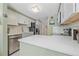 Modern kitchen features white cabinets, quartz countertops, and stainless steel appliances at 10389 W Fair Ave # E, Littleton, CO 80127