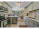 Updated kitchen boasts stainless steel appliances, gray cabinets, and view of dining area at 10389 W Fair Ave # E, Littleton, CO 80127
