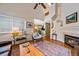 Open-concept living room with a fireplace, hardwood floors, and view of the dining area at 10389 W Fair Ave # E, Littleton, CO 80127