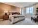 A bright bedroom with a decorative wall hanging, and a gray upholstered chair at 14160 Bunny Hop Ln, Parker, CO 80134