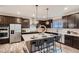 Modern kitchen with stainless steel appliances, dark wood cabinets, and a spacious center island with seating at 14160 Bunny Hop Ln, Parker, CO 80134
