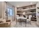 Home office with built-in shelves, a modern desk, and a comfortable seating area at 14160 Bunny Hop Ln, Parker, CO 80134