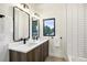 Modern bathroom featuring a double vanity, sleek mirrors, and tiled walls at 4101 S Lincoln St, Englewood, CO 80113