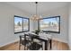 Bright dining room with a modern chandelier, a black table and large windows offering neighborhood views at 4101 S Lincoln St, Englewood, CO 80113