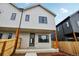 Modern townhouse featuring light siding, dark trim, fenced yard, and covered porch entry at 4101 S Lincoln St, Englewood, CO 80113