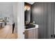 Stylish powder room featuring a dark vanity, gold fixtures, and wood accent wall detail at 4101 S Lincoln St, Englewood, CO 80113