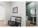 Inviting entryway with a black bench and view of a well-lit powder room with modern fixtures at 455 Rogers Way, Castle Rock, CO 80104