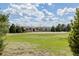Expansive front yard with mature trees and lush green lawn leading up to this distinctive stucco home at 1764 Mesa Ridge Ln, Castle Rock, CO 80108