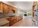 Well-lit kitchen with wood cabinets and stainless steel appliances open to living area with fireplace at 1764 Mesa Ridge Ln, Castle Rock, CO 80108