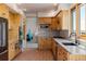 Open kitchen with wood cabinets, stainless appliances, granite counters, and brick tile flooring at 1764 Mesa Ridge Ln, Castle Rock, CO 80108