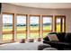Cozy living room features a wall of expansive windows offering panoramic views, complemented by stylish ottomans at 1764 Mesa Ridge Ln, Castle Rock, CO 80108