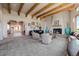 Bright open floorplan, showcasing a living room with a fireplace, wooden beams, and expansive windows at 1764 Mesa Ridge Ln, Castle Rock, CO 80108