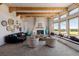 Bright living room with wooden beams, fireplace, multiple large windows with views, and modern décor at 1764 Mesa Ridge Ln, Castle Rock, CO 80108