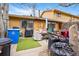 View of the backyard with an outdoor grill, artificial turf, and yard waste at 12458 E Kansas Pl, Aurora, CO 80012