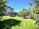 Lush backyard featuring a well-maintained lawn, mature trees, and a cozy patio with a pergola at 15857 E Aberdeen Ave, Centennial, CO 80016