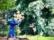 Backyard garden scene with a birdbath, bird feeder, butterfly art, and lush foliage at 15857 E Aberdeen Ave, Centennial, CO 80016