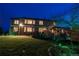Backyard view of multi-story home, including deck, patio and landscaped yard at twilight at 15857 E Aberdeen Ave, Centennial, CO 80016