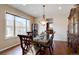 Formal dining room with hardwood floors, a large window, and a stylish chandelier above a dark wood table at 15857 E Aberdeen Ave, Centennial, CO 80016