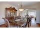 Elegant dining room featuring a dark wood table, china cabinet, and views into the bright, open living spaces at 15857 E Aberdeen Ave, Centennial, CO 80016