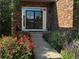 Brick home featuring a walkway leading to a front door with black trim and decorative flower beds at 15857 E Aberdeen Ave, Centennial, CO 80016