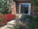 Charming brick home entrance featuring a beautiful red rose garden and mature trees and plantings at 15857 E Aberdeen Ave, Centennial, CO 80016