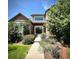 Inviting front entrance with brick facade, decorative door, lush landscaping, and charming walkway at 15857 E Aberdeen Ave, Centennial, CO 80016
