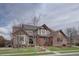 Charming two-story brick home featuring a manicured lawn, bay windows, and a beautifully tiled roof at 15857 E Aberdeen Ave, Centennial, CO 80016