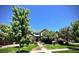Charming two-story home featuring a lush front yard, mature trees, and manicured landscaping at 15857 E Aberdeen Ave, Centennial, CO 80016