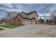 Spacious three-car garage with a wide driveway, surrounded by well-kept landscaping and a wooden fence at 15857 E Aberdeen Ave, Centennial, CO 80016