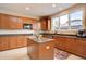Well-lit kitchen featuring an island, lots of cabinetry, granite countertops, and modern appliances at 15857 E Aberdeen Ave, Centennial, CO 80016