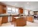 Open kitchen with custom wood cabinets, granite countertops, a center island, and stainless steel appliances at 15857 E Aberdeen Ave, Centennial, CO 80016