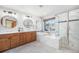Bright bathroom with double vanity, soaking tub, and glass-enclosed shower, perfect for relaxation and rejuvenation at 12518 W 77Th Pl, Arvada, CO 80005
