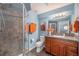 Modern bathroom with glass shower, vanity, and natural lighting at 12518 W 77Th Pl, Arvada, CO 80005