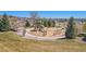 Outdoor playground with slides, climbing structures, and pea gravel surfacing, surrounded by well-manicured grass and trees at 12518 W 77Th Pl, Arvada, CO 80005