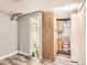 Basement area with gray walls, wood-look floors, wooden cabinets, and a bathroom featuring checkerboard tile at 1856 S Steele St, Denver, CO 80210
