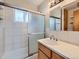 Bathroom featuring a glass enclosed tub/shower, white tiled walls, and a sink at 1856 S Steele St, Denver, CO 80210
