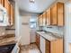 A kitchen featuring light wood cabinetry, granite countertops, and modern appliances at 1856 S Steele St, Denver, CO 80210