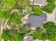 Aerial view of the house with a spacious yard, inviting patio, mature trees, and serene landscaping at 2205 Santa Fe Dr, Longmont, CO 80504