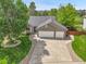 Beautiful exterior elevation with a well-manicured lawn, mature trees and a three-car garage at 2205 Santa Fe Dr, Longmont, CO 80504