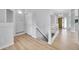Hallway features light wood floors, neutral walls, modern railings, and access to the home's entrance at 2205 Santa Fe Dr, Longmont, CO 80504