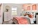 Bright bedroom featuring a large window, modern dresser, and stylish decor with coral accents at 39682 Penn Rd, Elizabeth, CO 80107