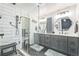 Bathroom featuring a glass-enclosed shower, modern fixtures, gray cabinets and patterned tile flooring at 1470 S Quebec Way # 8, Denver, CO 80231