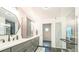 Bright bathroom featuring a double vanity, unique mirrors and glass enclosed shower at 1470 S Quebec Way # 8, Denver, CO 80231