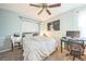 Bedroom with light blue walls, a bed, desk and fan with natural light streaming in from a window at 1470 S Quebec Way # 8, Denver, CO 80231