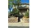 Inviting townhome with a brick facade, complemented by lush landscaping and a stone retaining wall, leading to a welcoming front entrance at 1470 S Quebec Way # 8, Denver, CO 80231