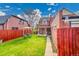 The spacious backyard has lush green grass, and a charming fence at 3070 Colorado Blvd, Denver, CO 80207