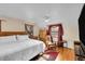 Bedroom with a large bed, ceiling fan, wood furniture, and window with burgundy curtains at 3070 Colorado Blvd, Denver, CO 80207